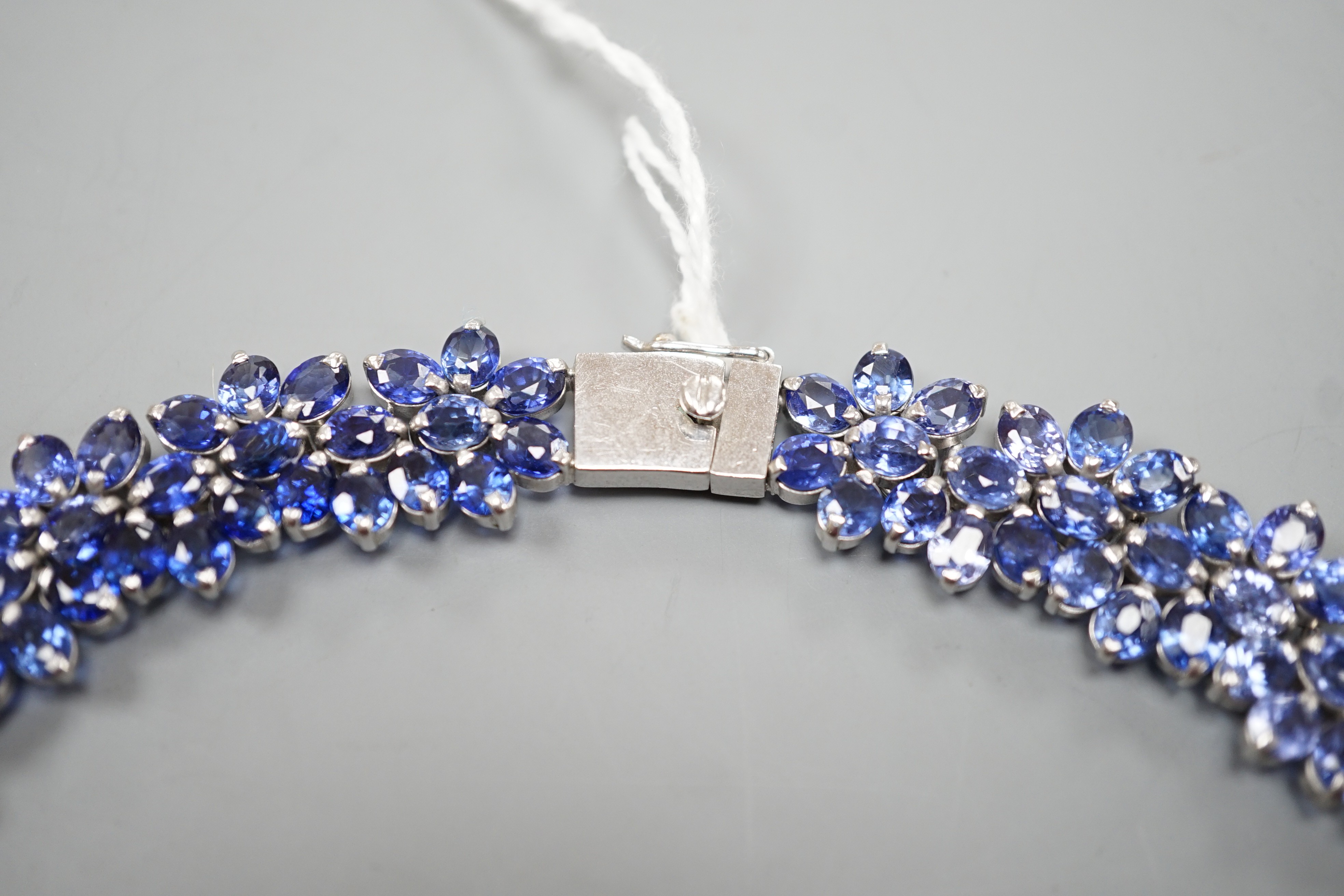 A continental base metal and synthetic sapphire? flower head cluster set necklace, approximately 39cm.